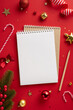 © ActionGP - Festive Christmas vertical setting with baubles, candy canes, and blank notepad on red background, perfect for holiday planning or messages