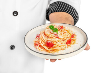 professional chef holding plate with tasty pasta Dish with tomato sauce and basil isolated on white background