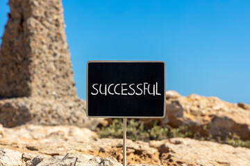 Successful symbol. Concept word Successful on beautiful chalk blackboard. Beautiful red stone and blue sky background. Business successful concept. Copy space.