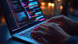 © john - Hands typing on a laptop with colorful code on screen.
