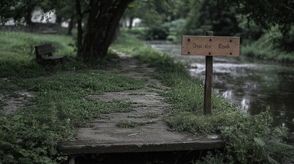 Poster - A serene path by a river with a signpost and a bench, surrounded by lush greenery.