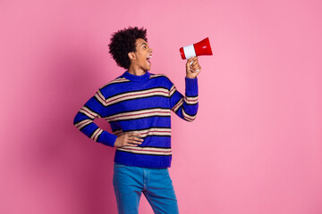 Poster - Photo of eccentric man guy with wavy hair dressed knitwear sweater scream in megaphone look empty space isolated on pink color background