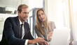 © ThurstanJam/peopleimages.com - Man, woman or laptop in office for advice, business meeting or report for company growth. People, tech or discussion in workplace for teamwork, brainstorming or budget planning for financial year end