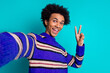 © deagreez - Photo of cheerful man guy with wavy hairstyle dressed knitwear sweater making selfie showing v-sign isolated on blue color background