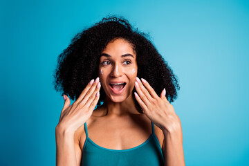 Wall Mural - Photo of excited girl look with cream lotion on her face isolated blue color background