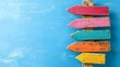 © Creative Art7 - a wooden signpost with colorful arrows pointing in different directions on a blue background, symbolizing multiple options and choice concepts