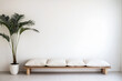 © JuanM - Modern minimalist seating area featuring a wooden bench with cushions and a potted palm plant against a white wall