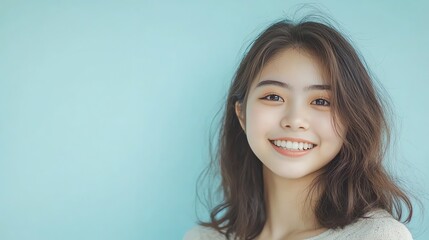 A young woman with long, dark hair smiles at the camera.