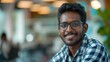 © ANC Media - A cheerful Indian man poses confidently in a contemporary office environment