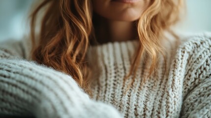 A close-up of a woman wearing a cozy, knit woolen sweater, evoking feelings of warmth, comfort, and the gentle embrace of soft, homey clothing in a serene, indoor setting.