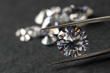 Poster - Many beautiful shiny diamonds and tweezers on black table, closeup