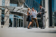© qunica.com - Three business professionals engage in a dynamic conversation outside a modern office building, showcasing teamwork and collaboration.