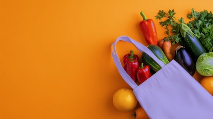 Fresh vegetables in a reusable bag against a vibrant orange background in a bright kitchen