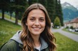 © ThomasLENNE - Close portrait of a smiling young Swiss woman looking at the camera, Swiss outdoors blurred background