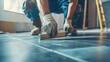 © Johannes - Professional tiler placing level in position with lash tile leveling system and clamp level ceramic tiles. Flooring and tiling concept.