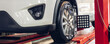 © kanpisut - Car wheel centering machine adjustment. Auto service mechanic installing wheel alignment sensor on tire during vehicle suspension alignment adjustment