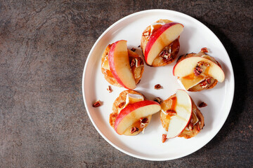 Poster - Plate of crostini appetizers with red apples, brie cheese and walnuts. Overhead view against a dark background. Party food concept.