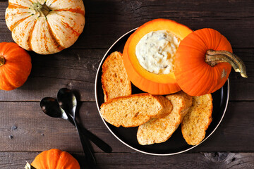 Aufkleber - Fall pumpkin theme appetizer with spinach dip and toasted baguettes. Top down view table scene against a dark wood background. Autumn party food concept.