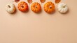 © Galeno - A flat lay of stylish Halloween pumpkins and dried leaves on a soft pastel beige background, creating an elegant autumn vibe