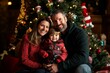 © woters - Family portrait celebrating the holiday season in front of a beautifully decorated Christmas tree indoors