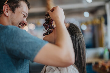 Poster - Two friends are laughing and sharing fresh grapes at a vibrant farmers market. Capturing joy and friendship in a lively setting.