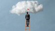 © Business Image - Business success concept: man on ladder reaching for cloud ambition