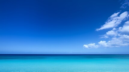 Canvas Print - Tranquil blue ocean horizon with fluffy white clouds in a clear sky.