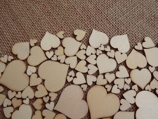 wooden hearts of different sizes on jute fabric as a Valentine's day greeting card. High quality photo