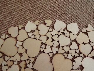 wooden hearts of different sizes on jute fabric as a Valentine's day greeting card. High quality photo