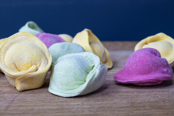 Frozen, green, pink and yellow raw dumplings. Copy space for your advertisement and text