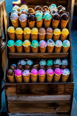 A huge wooden box filled with a hundred ice cream cones, each in a classic waffle cup.