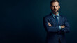 © Michael - Confident businessman with folded arms stands against a dark backdrop, dressed in a suit and tie