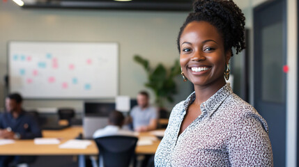 Wall Mural - Confident young businesswoman smiles in a modern open plan office as her team works in the background