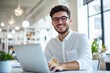 © kitipol - High-resolution brightly lit photorealistic candid photograph of a young marketer in casual attire, smiling while working on his laptop in a bright office. The photograph is styled like a high-end