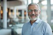 © LadiesWin - Portrait of successful senior Persian businessman consultant looking at camera and smiling inside modern office building , background blur