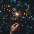 © malik - bright festive Christmas and happy new year sparkler in hand . Woman hand holding a burning sparkler. Christmas and new year sparkler holiday background