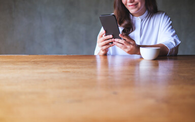 Poster - Closeup image of a young woman holding and using mobile phone