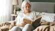 © CK Studio - A serene elderly woman with silver hair sits comfortably in bed, engrossed in a book, basking in soft morning light.