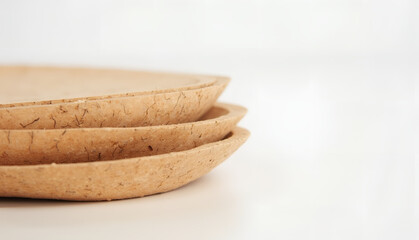 Wall Mural - close-up of a stack of eco-friendly cork sheets shaped like bowls against a minimalist white backgro