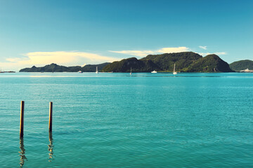 
A beautiful view of Langkawi island against a beautiful blue sky with  some boats in the distance on the horizon. Tropical scenery. located at Kedah, Malaysia - September  25  2024: