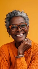 Wall Mural - A woman with short hair and glasses is smiling and wearing an orange sweater