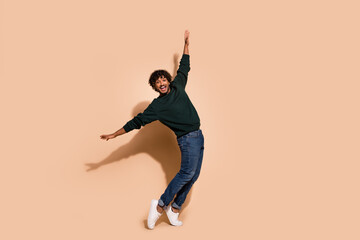 Poster - Full size photo of nice young man stand tiptoe dance wear sweater isolated on beige color background