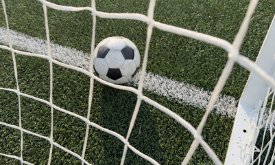 Wall Mural - Soccer ball in goal on blue background