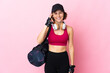 © luismolinero - Young sport woman with sport bag over isolated background showing ok sign with fingers