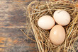 © shephotos - Chicken eggs white and brown color wrapped in hay on wooden table background. International world egg day concept. Farm products and natural nutrition. Copy space. Space for text