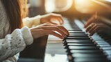 Woman's hands playing piano keys with sunlit background.
