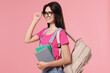 © New Africa - Portrait of cute teenage girl with backpack and books on pink background