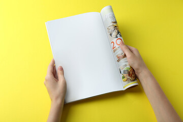 Poster - Woman reading magazine on yellow background, top view. Mockup for design