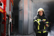 © New Africa - Portrait of firefighter in uniform with high pressure water jet near fire truck outdoors