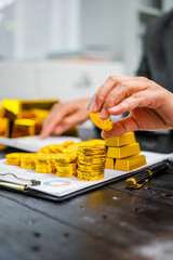 Businessman in suit sits at his desk, holding a shining gold bar. financial charts, the scene symbolizes wealth, investment success, growing influence of cryptocurrency and blockchain.